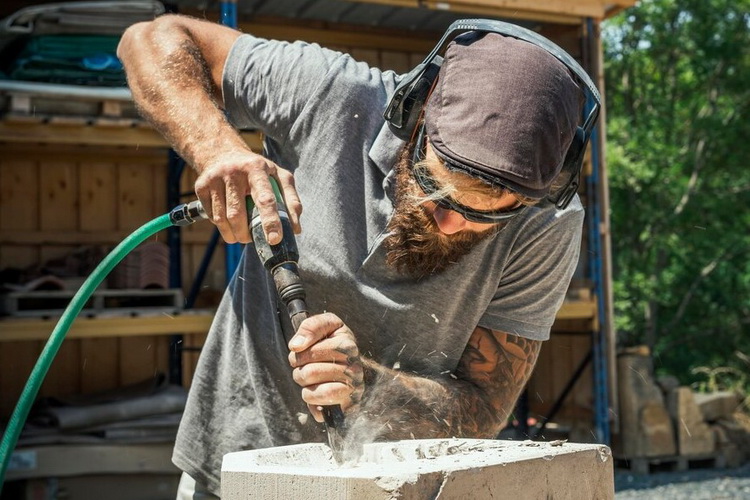 A skilled mason working on a stone and brick wall construction